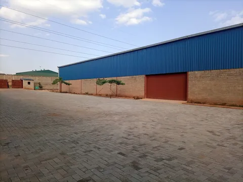 Large factory unit interior at Namanve industrial park showing high ceiling trusses, concrete floor, and industrial power supply conduits.